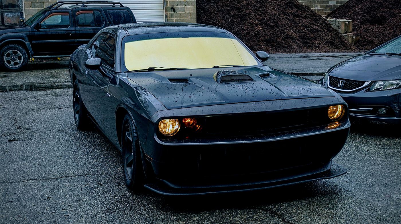 Black Dodge Challenger with dark tint at dusk